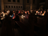 Mitfeiernde entzünden ihr Licht an der Osterkerze - Osternacht-Lichtfeier 2023